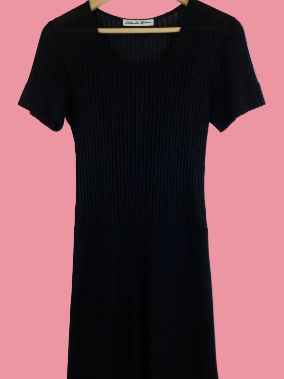 Black ribbed dress on a pink background
