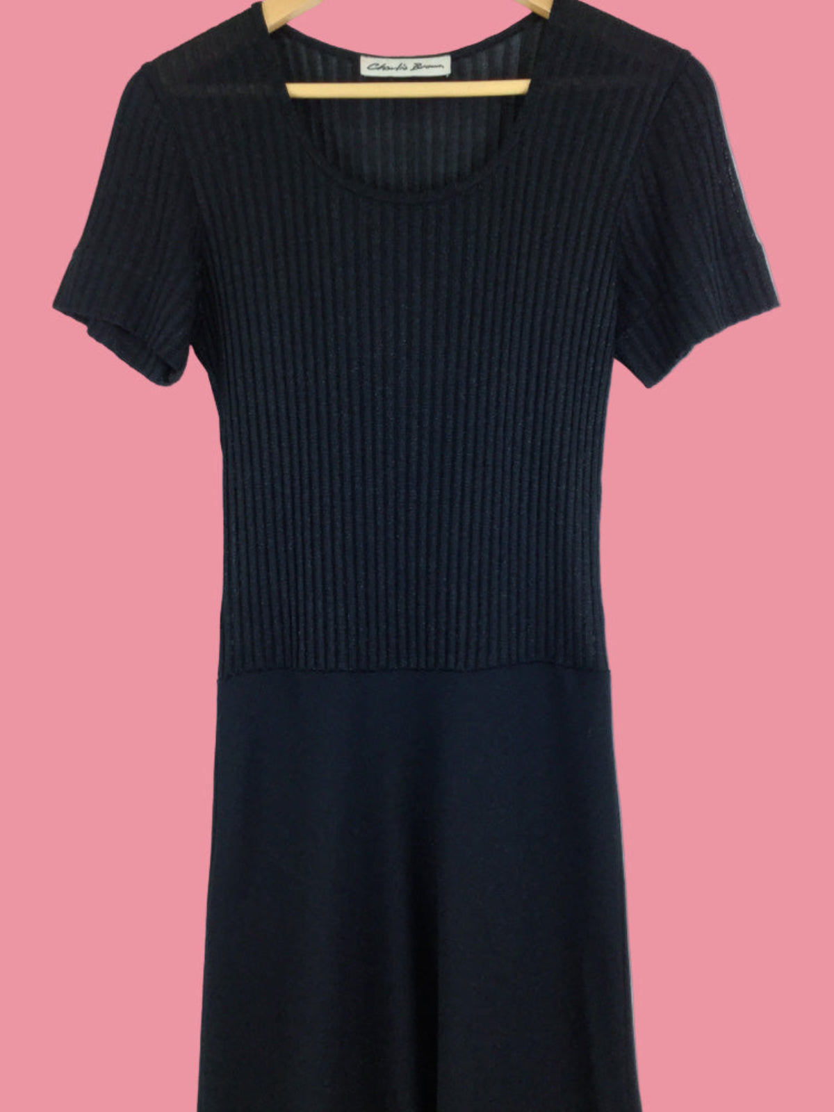 Black ribbed dress on a pink background