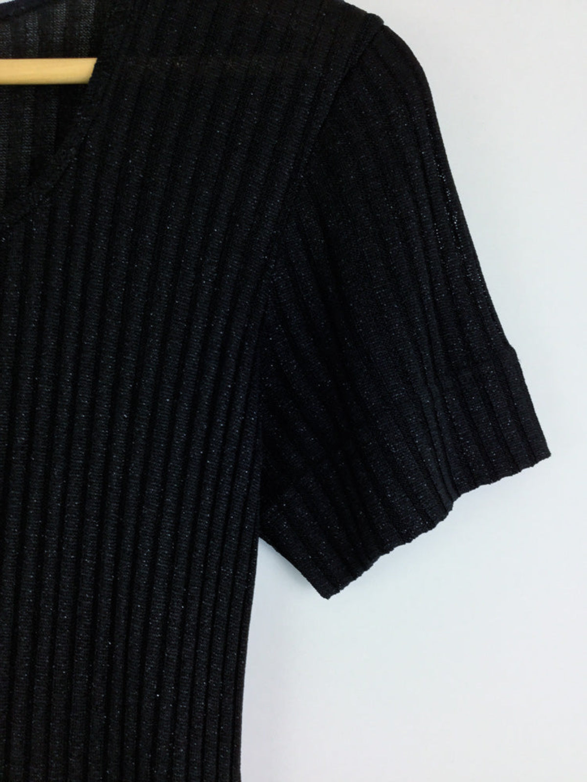 Black ribbed dress on a hanger against a white background