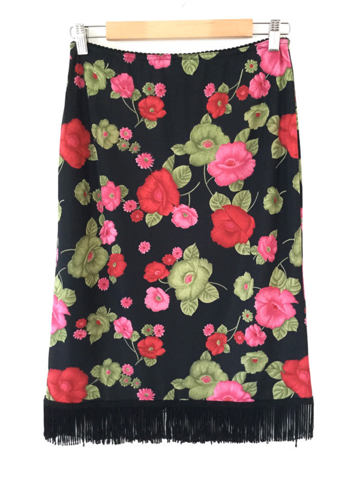 Vintage 90's floral print skirt with big bold flowers in pink, red & green on a black backdrop with an elastic waistband and black fringing on the hem