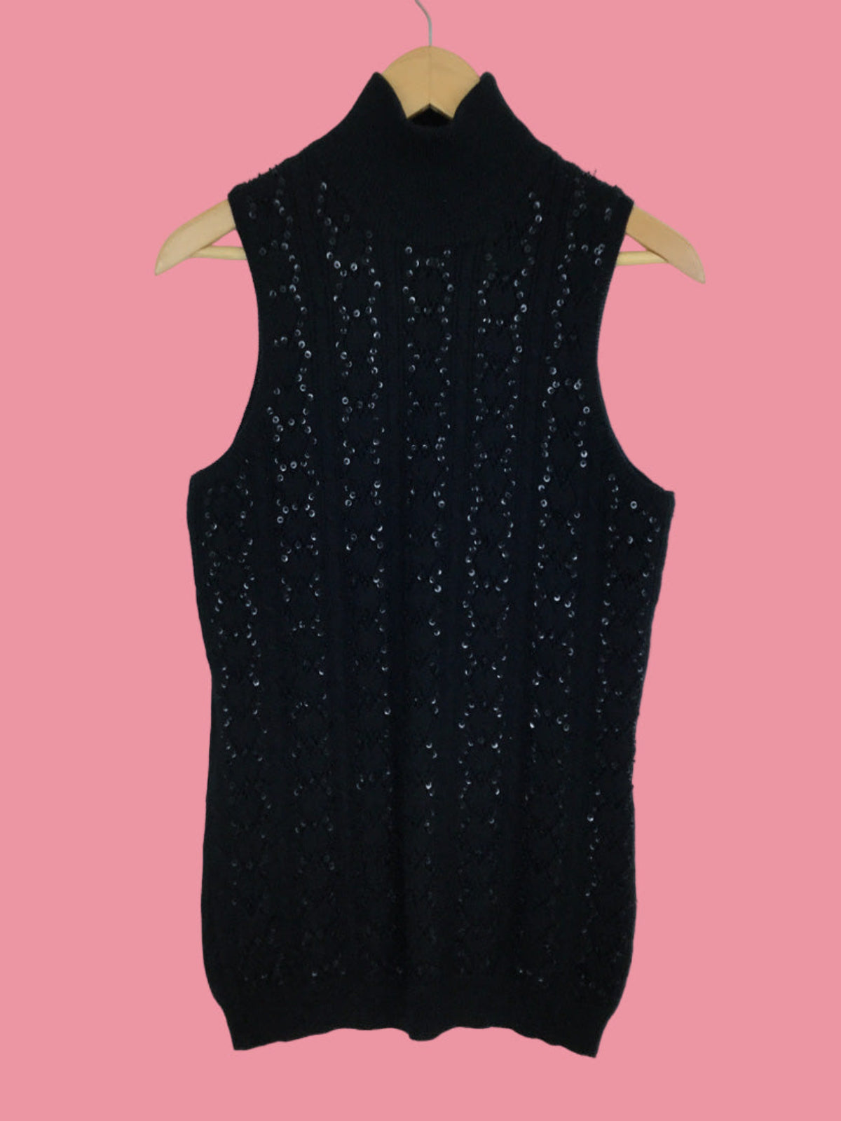 Black sleeveless sparkly top on a pink background