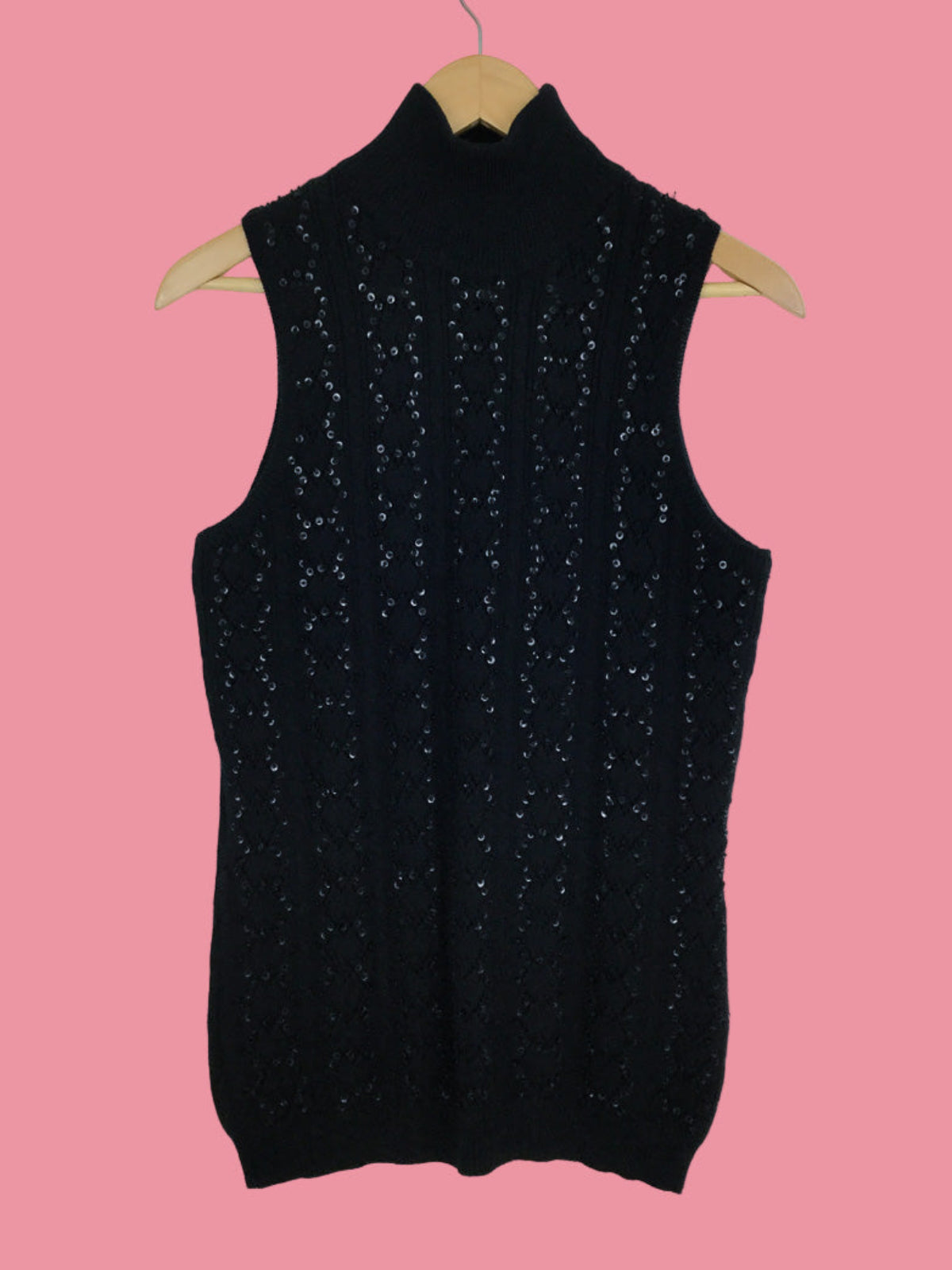 Black sleeveless top with sequin details on a pink background
