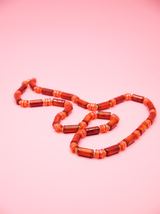 Orange & brown resin tube bead necklace with brass spacer beads and a brass clasp closure