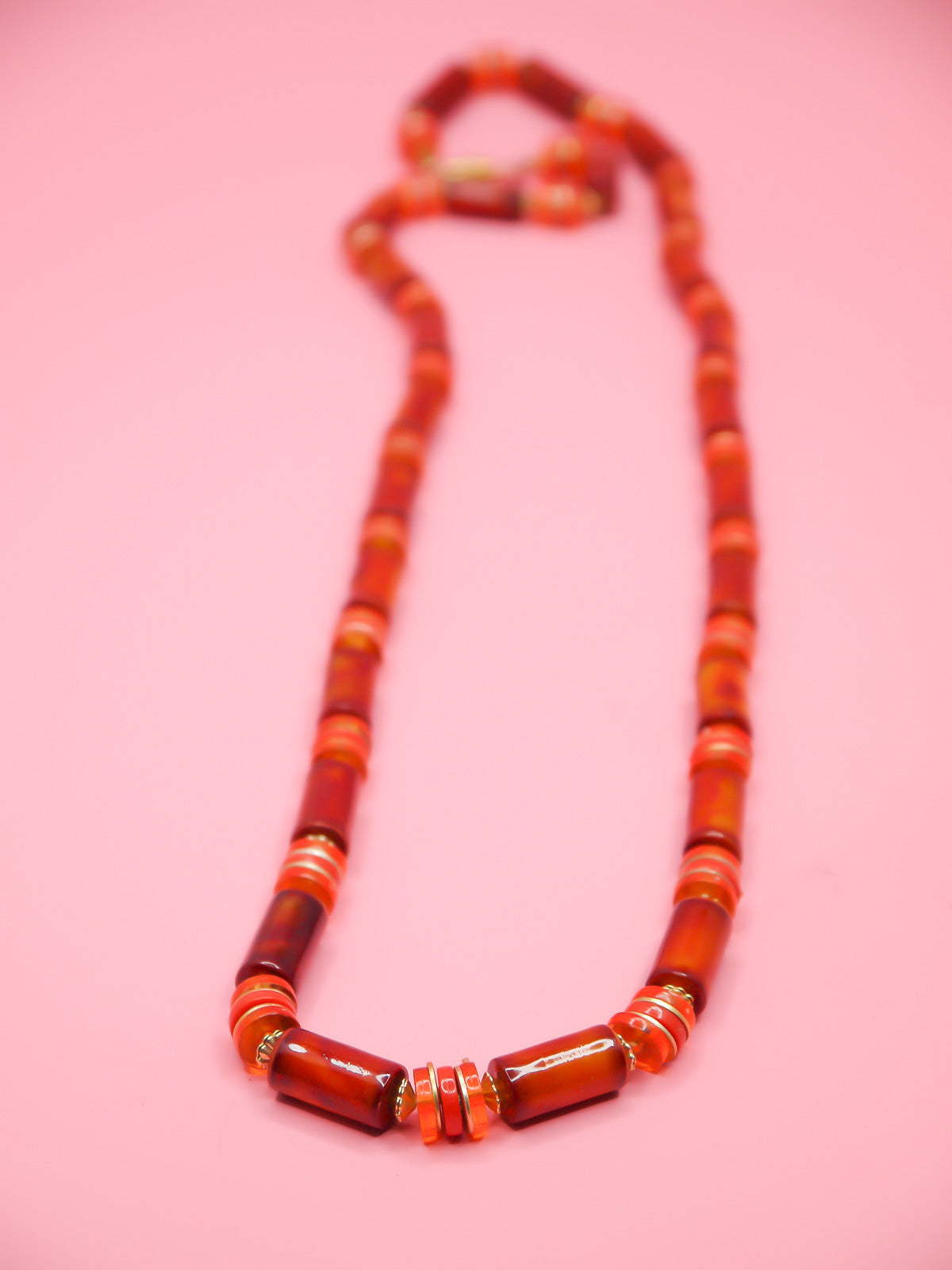 Orange & brown resin tube bead necklace with brass spacer beads and a brass clasp closure