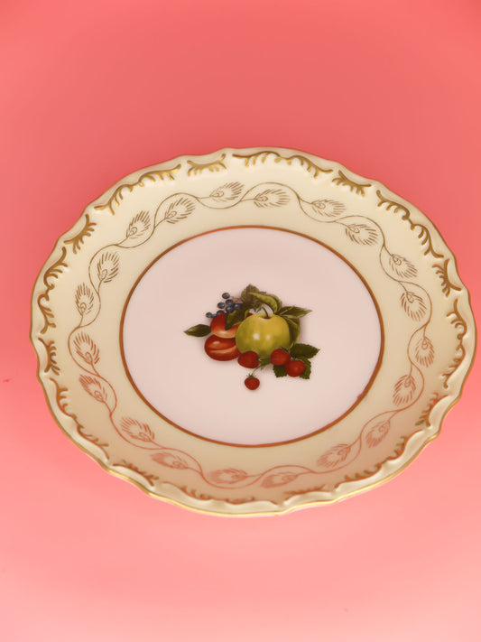 Vintage Dianti decorative plate with fruit in the centre on a white background with gold edging and gold patterns around the rim