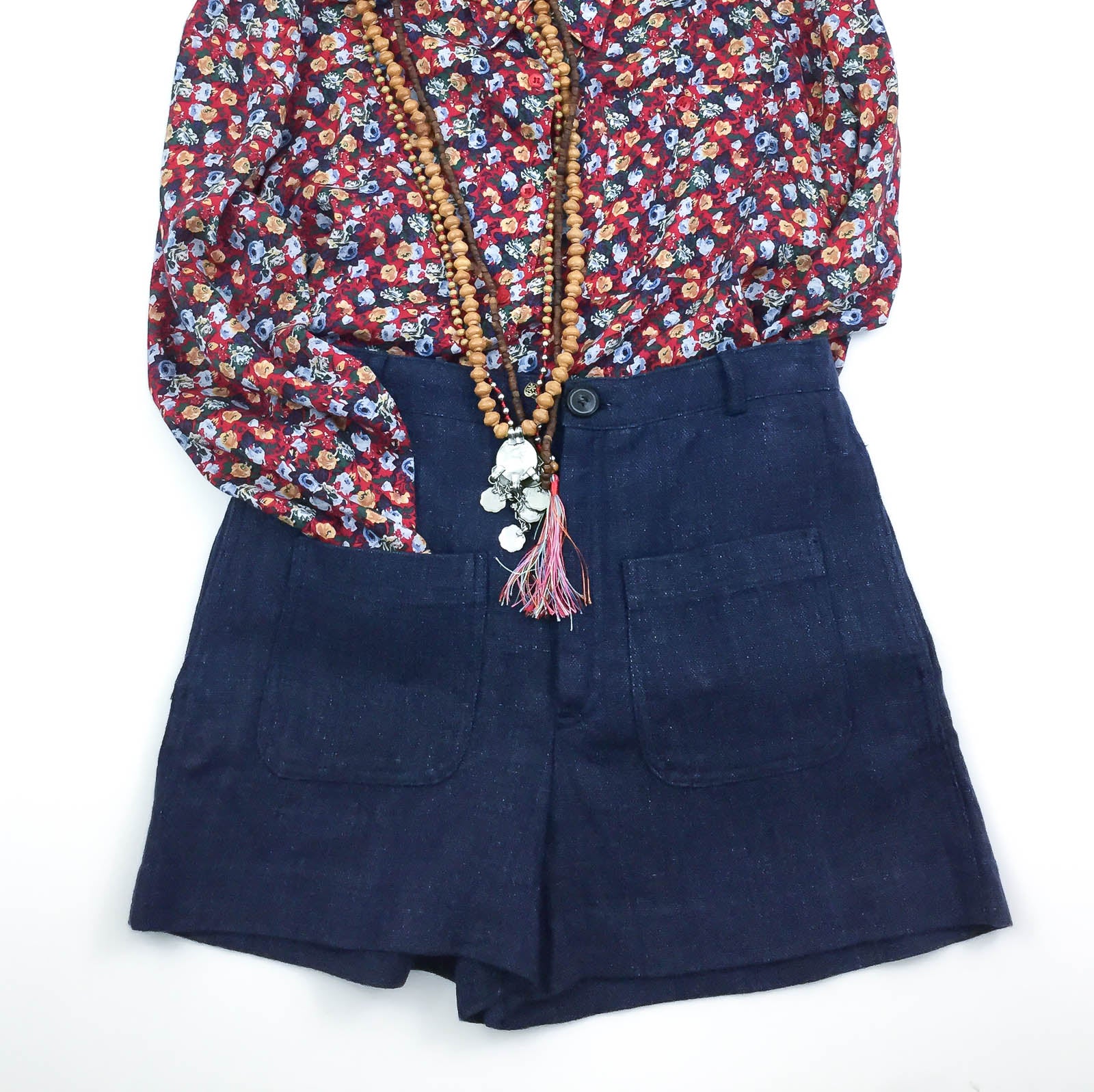 Vintage at Goto floral print shirt with layered bead tassel necklaces tucked into dark denim shorts 