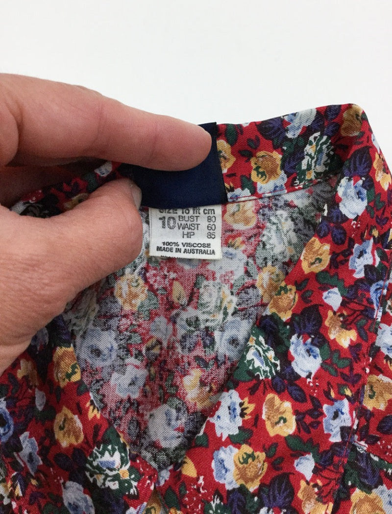 Vintage 90's boho floral print lightweight long sleeve shirt in reds, blues, brown & green. Has a pocket on the front left hand side with button closure all down the front.