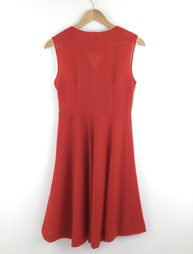 1970's red v-neck sleeveless sheer a-line dress with white piping around the arms and neckline with white buttons down the front