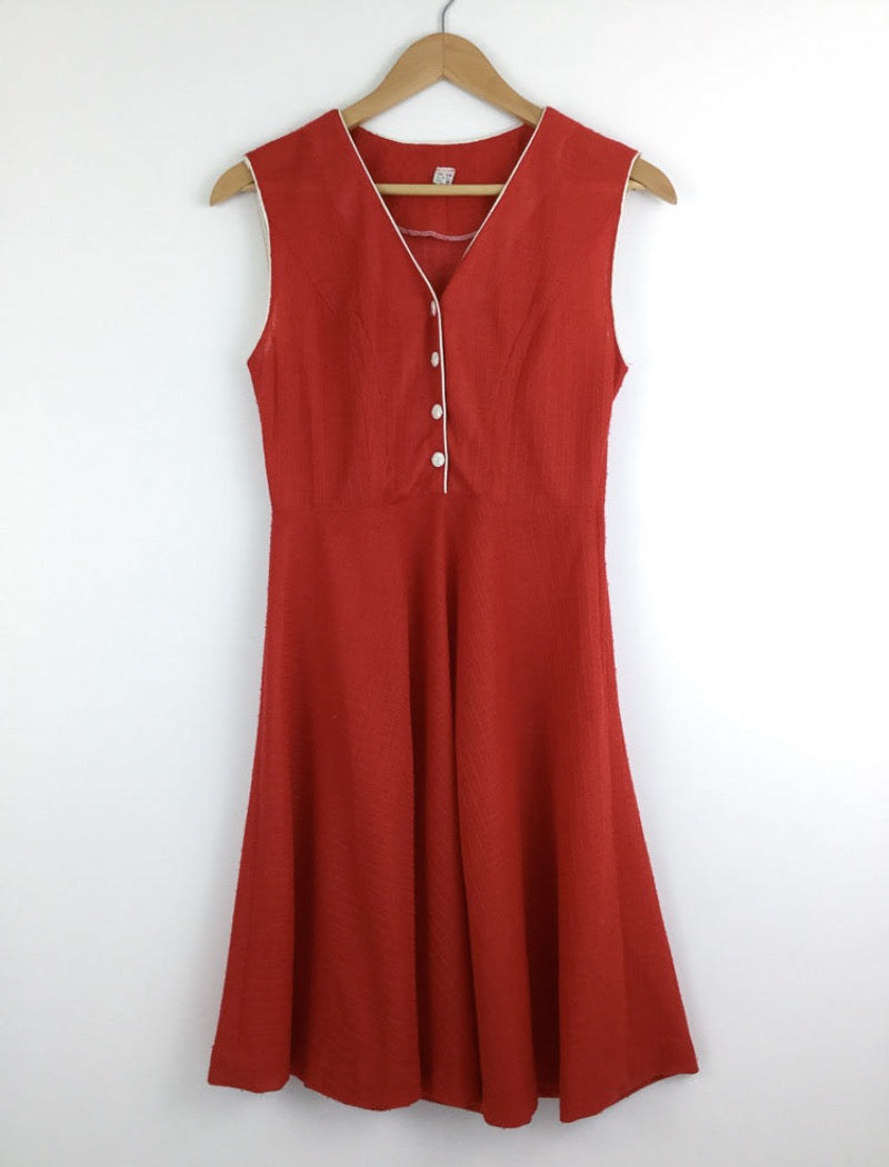 1970's red v-neck sleeveless sheer a-line dress with white piping around the arms and neckline with white buttons down the front