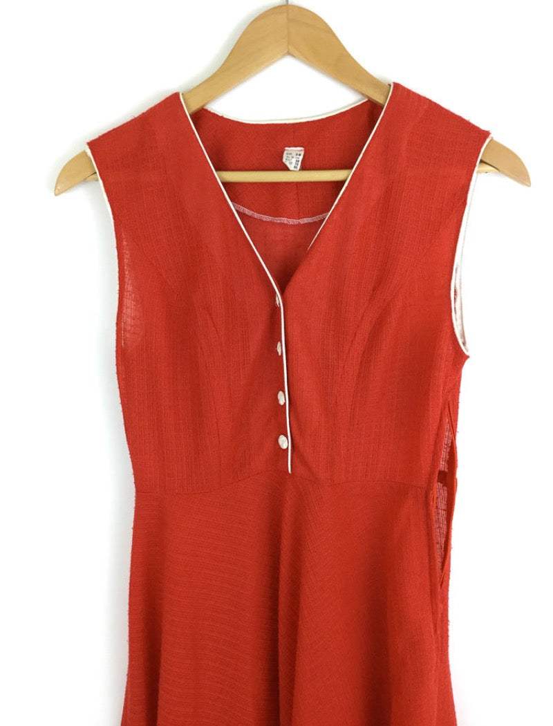 1970's red v-neck sleeveless sheer a-line dress with white piping around the arms and neckline with white buttons down the front