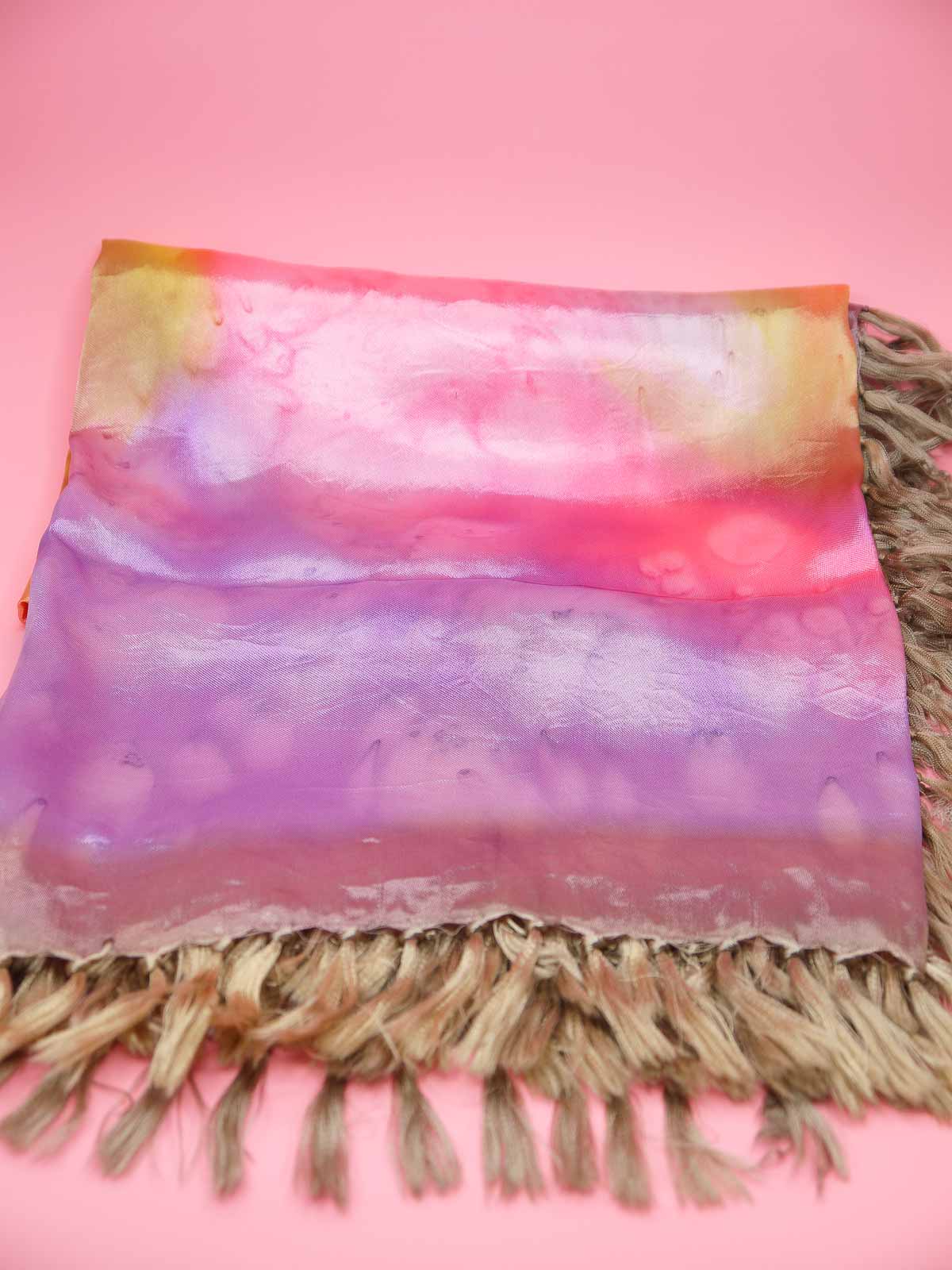 Tie dyed square fringed scarf shawl in colours of pinks, purples, gold with gold fringing and silky sheen to the fabric.